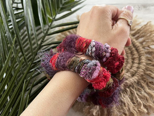 Woman wearing two yarn-wrapped bracelets