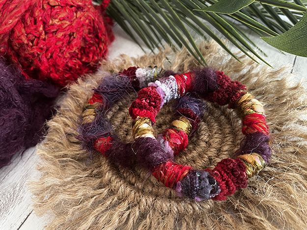 Two yarn-wrapped bracelets on an earthy jute coaster