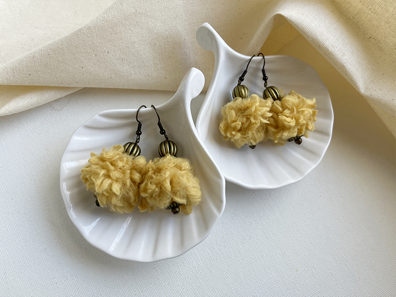 Two pairs of yellow yarn-wrapped ball earrings